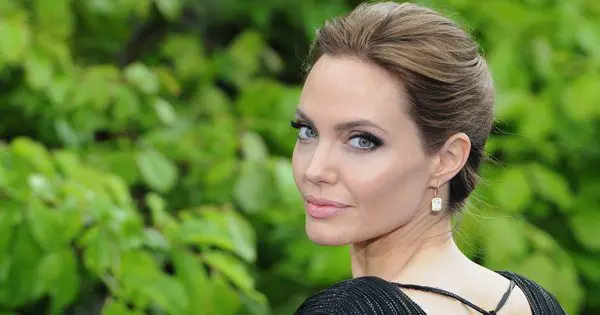 blog picture of angelina jolie turning around for the camera in front of foliage